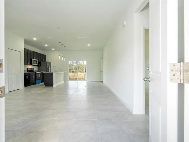 a view of a hallway with kitchen and kitchen island