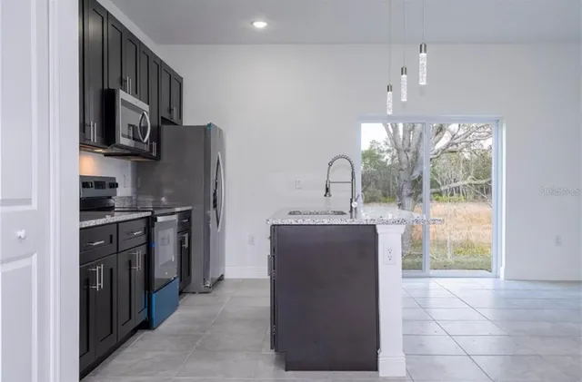 a kitchen with stainless steel appliances granite countertop a refrigerator and a sink