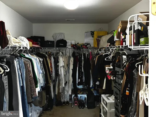a view of walk in closet with clothes