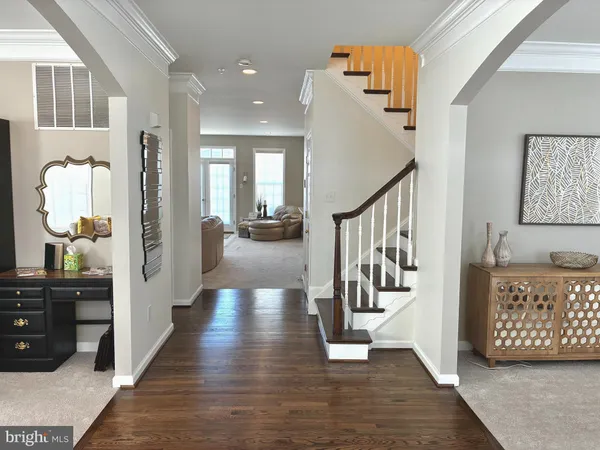 a view of a hallway with wooden floor and stairs