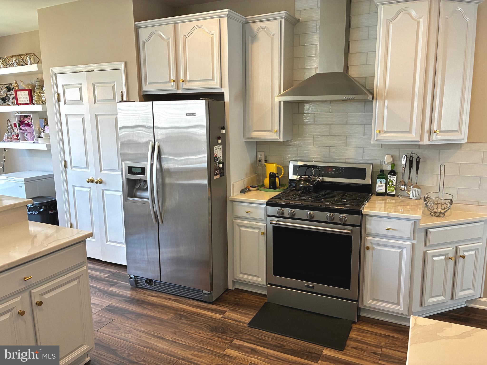 14301 Lightfoot Street Accokeek, MD 20607 - Photo 10 of 32 a kitchen with stainless steel appliances granite countertop a refrigerator a stove and a sink with cabinets