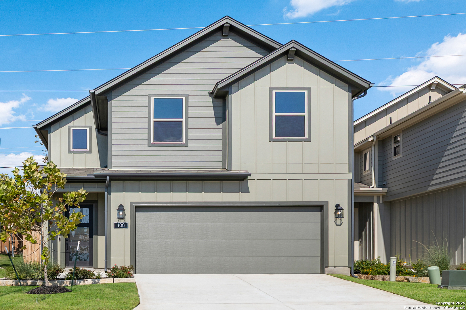 a view of a house with a yard and large tree
