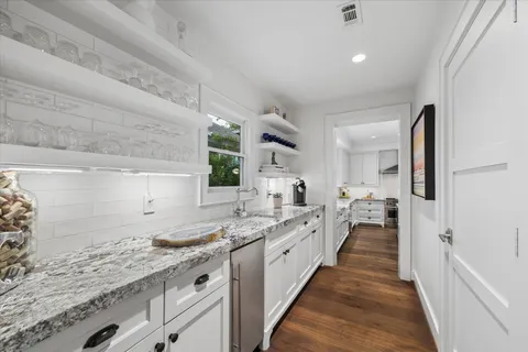 a large white kitchen with a sink and cabinets