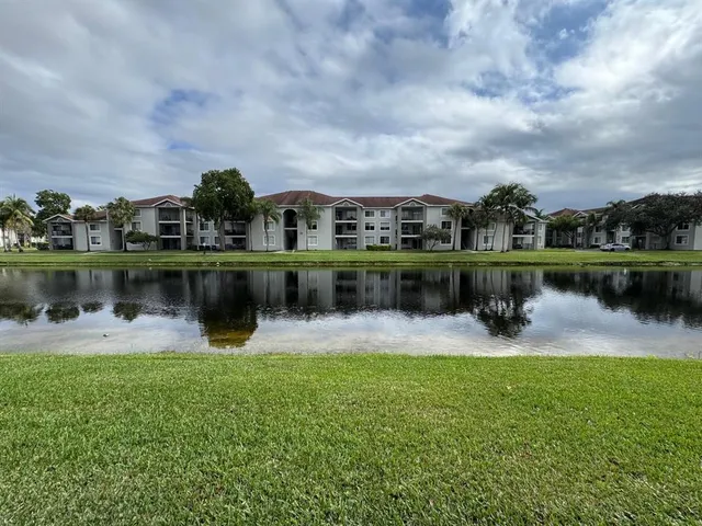 a lake view with a big yard and large trees
