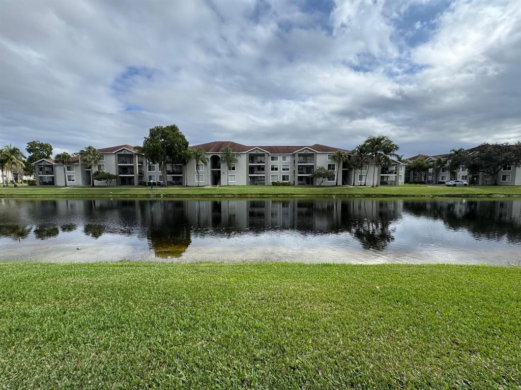 8060 North Nob Hill Road, Unit 106 Tamarac, FL 33321 - Photo 1 of 15 a lake view with a big yard and large trees