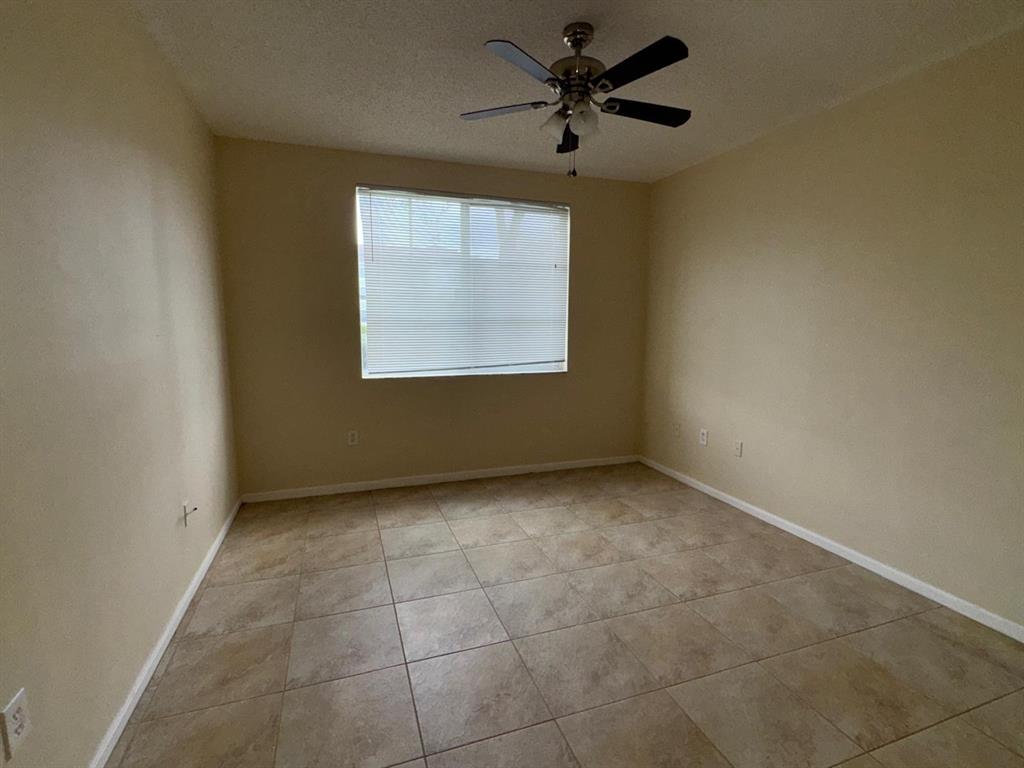 8060 North Nob Hill Road, Unit 106 Tamarac, FL 33321 - Photo 7 of 15 an empty room with windows and fan