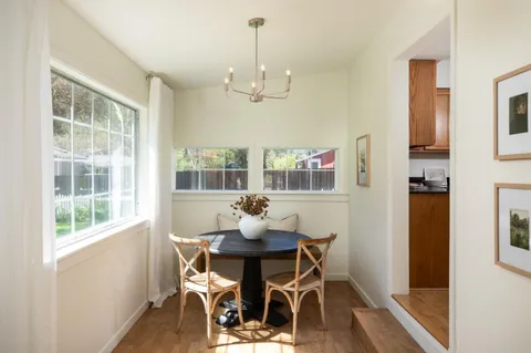 a dining room with furniture a chandelier and wooden floor