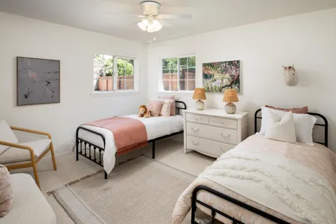 a bedroom with two beds and a chandelier