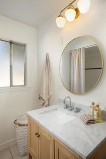 a bathroom with a granite countertop sink and a mirror