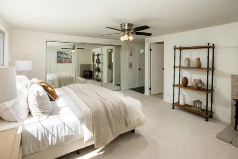 a spacious bedroom with a bed and a chandelier