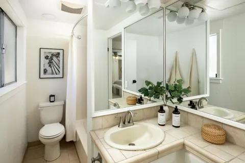 a bathroom with a granite countertop sink and a mirror