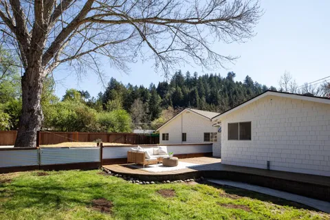 a view of a house with backyard and sitting area