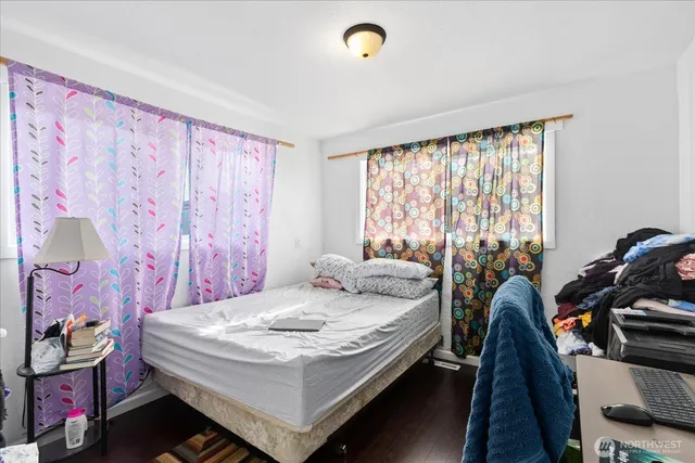 a bedroom with a bed and a dresser next to a window