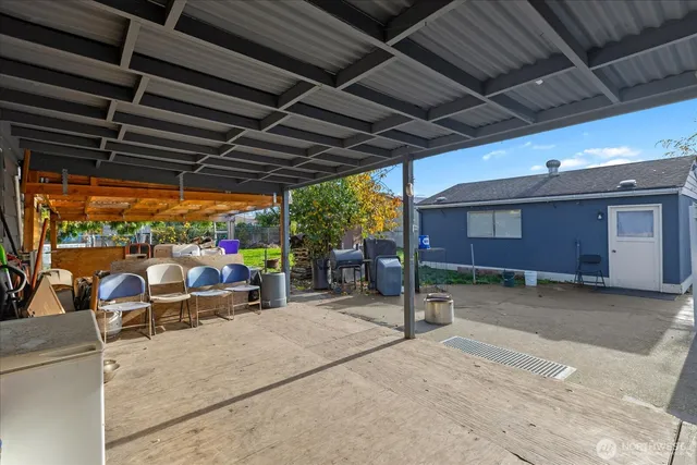 a view of a patio with a table and chairs under an umbrella