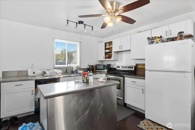 a kitchen with a refrigerator a sink and dishwasher a oven with white cabinets