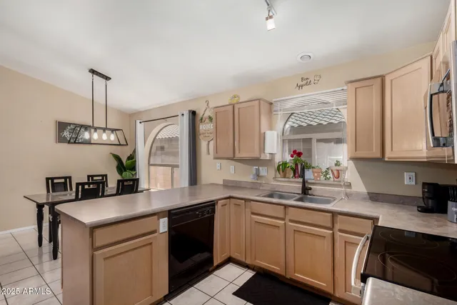 a kitchen with a sink dishwasher a stove and white cabinets with wooden floor