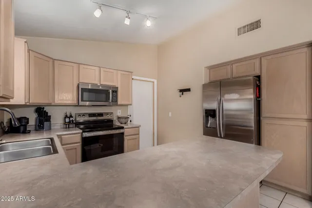 a kitchen with stainless steel appliances granite countertop a refrigerator a stove top oven a sink and dishwasher