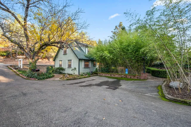 a view of a house with a yard and potted plants