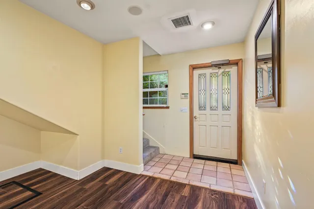 a view of a hallway with wooden floor and staircase