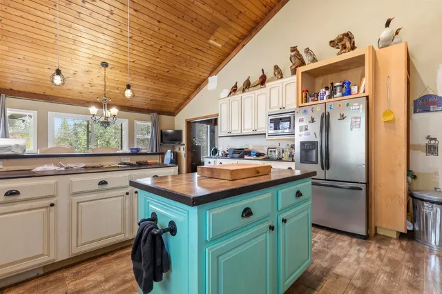 a kitchen with stainless steel appliances a sink a stove a refrigerator and cabinets