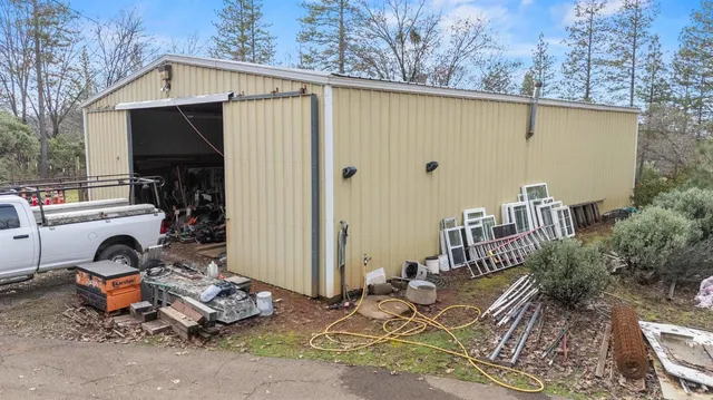 a view of a house with a large tree and wooden fence