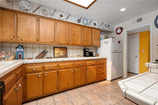 a kitchen with stainless steel appliances a stove a sink a counter space and cabinets