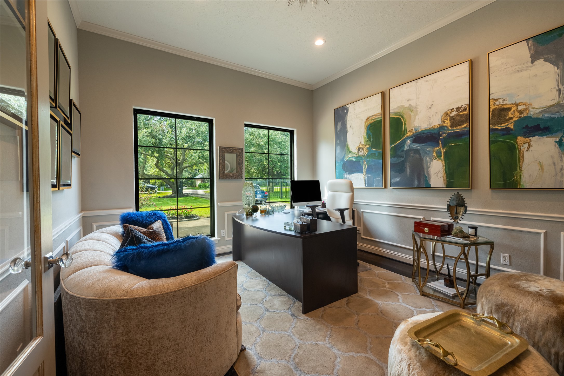 4002 Silver Ridge Boulevard Missouri City, TX 77459 - Photo 8 of 50 This is a well-lit, contemporary home office with large windows offering a view of greenery outside. It's styled with modern artwork, a cozy sitting area, and a sleek desk setup, ideal for work or relaxation.