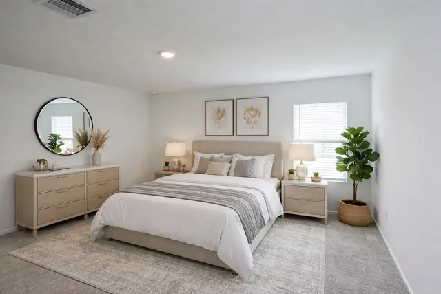 a bedroom with a bed and a potted plant