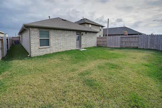 a view of a backyard with brick wall and garage