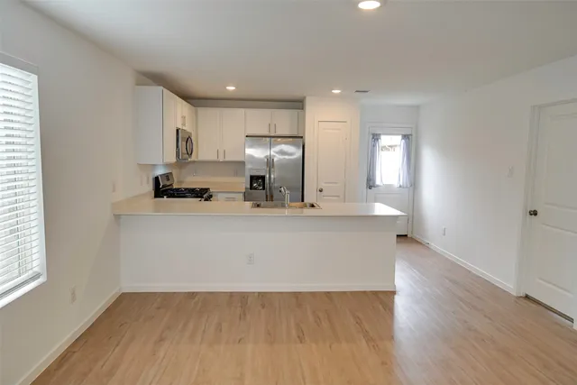a view of kitchen with wooden floor and electronic appliances