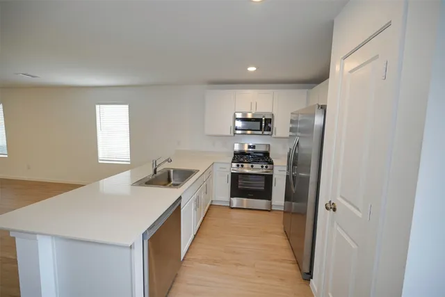 a kitchen with stainless steel appliances a refrigerator and a stove