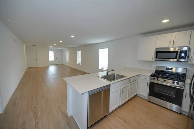 a kitchen with stainless steel appliances granite countertop a stove a sink and a microwave