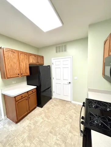 a kitchen with a refrigerator and a stove top oven