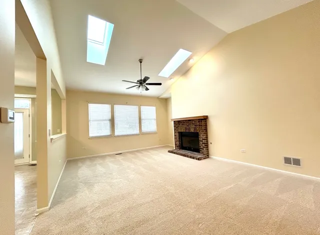 a view of an empty room with a fireplace and a window
