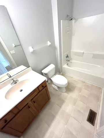 a bathroom with a double vanity sink toilet mirror and bathtub
