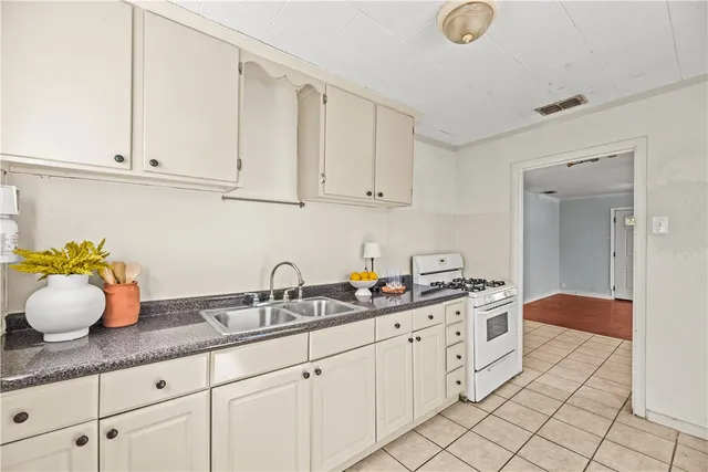 a kitchen with granite countertop white cabinets and white appliances