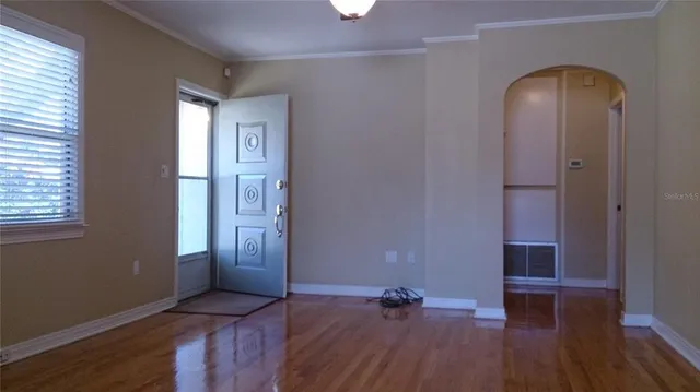 an empty room with wooden floor and a window