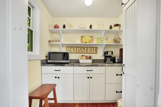 a kitchen with white cabinets and stove