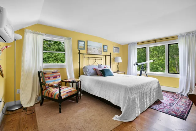 a bedroom with a bed and large windows