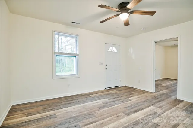 a view of an empty room and kitchen view