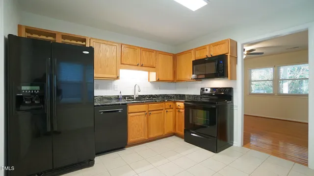a kitchen with granite countertop a refrigerator and a stove top oven