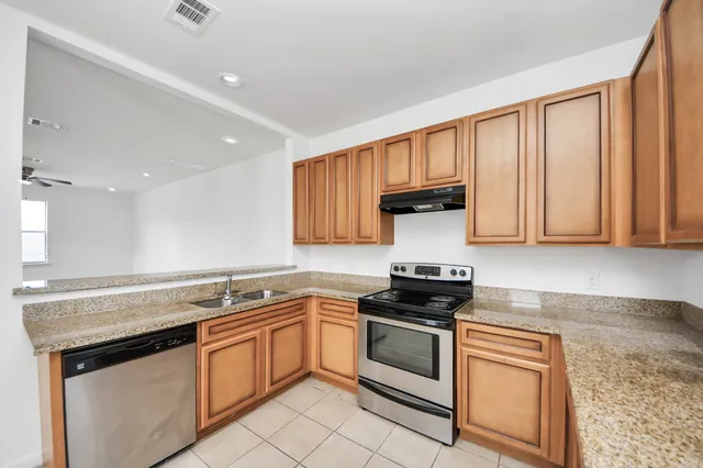a kitchen with granite countertop white cabinets and white appliances