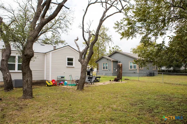a view of a house with backyard and tree