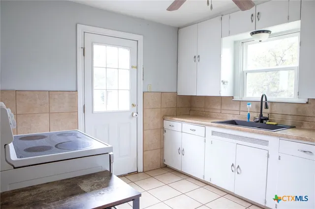 a kitchen with granite countertop white cabinets and white appliances