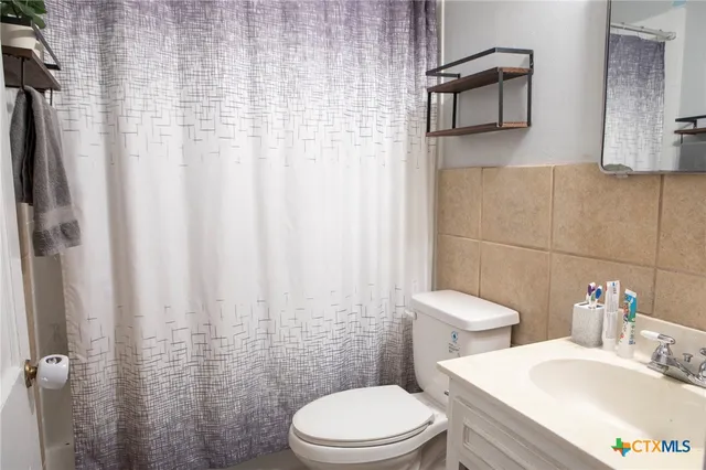 a white toilet sitting next to a bathroom sink