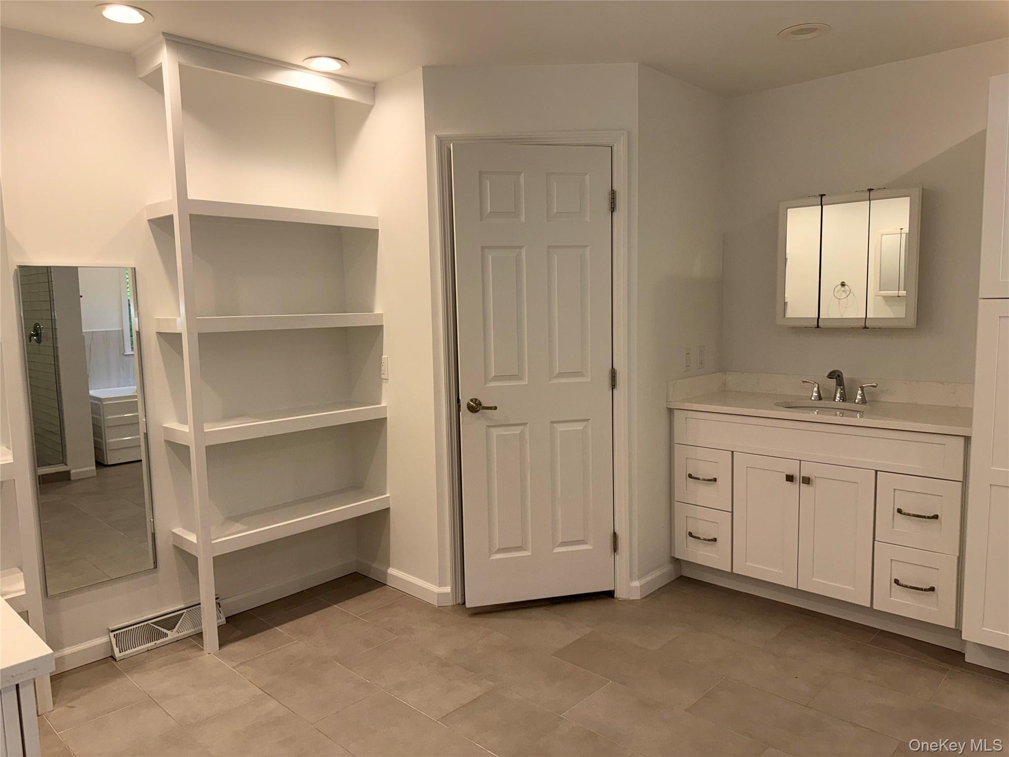 1661 Old Country Road, Unit 516 Riverhead, NY 11901 - Photo 44 of 50 a spacious bathroom with a double vanity sink and a mirror