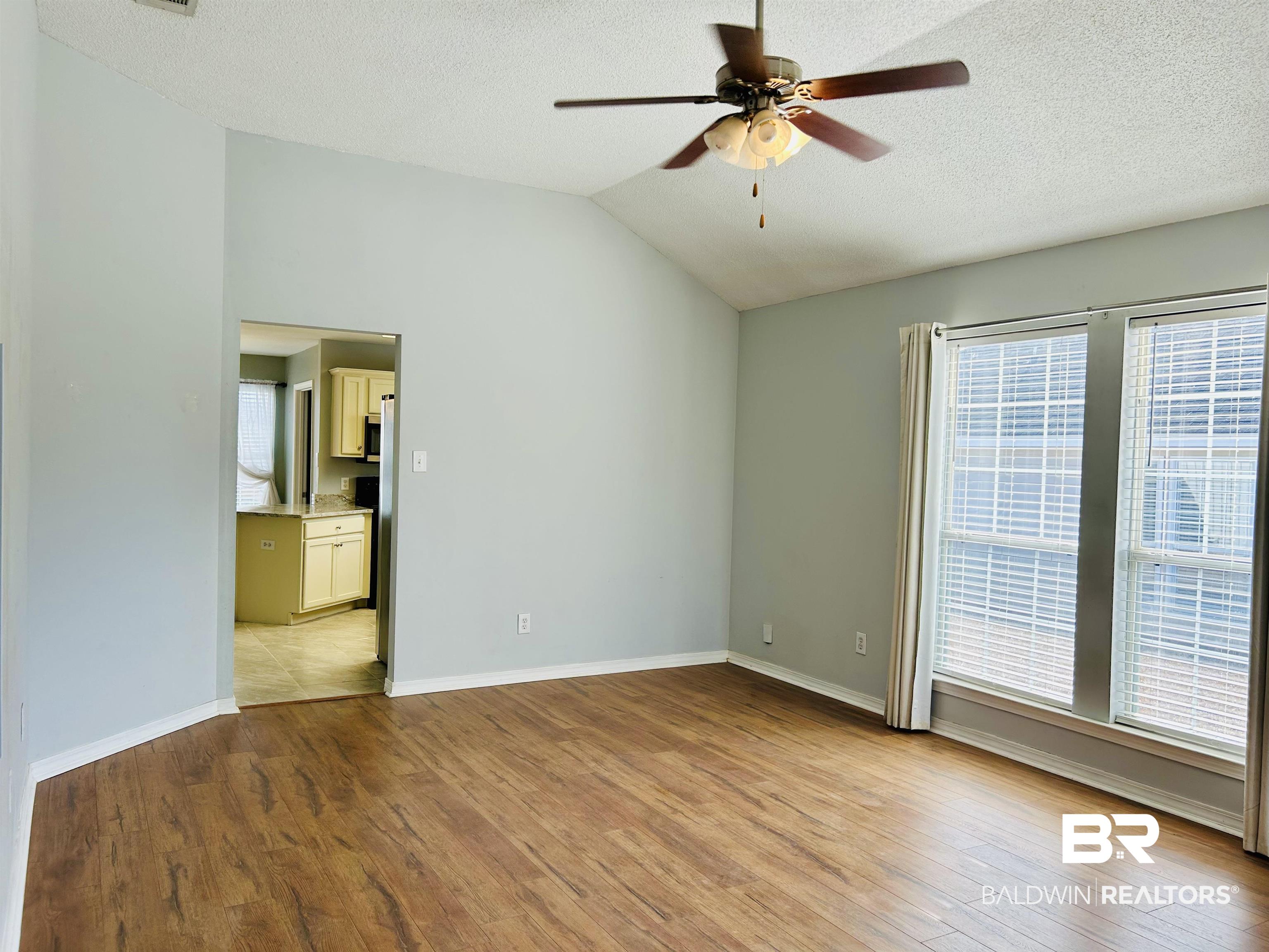 919 Parliament Court Mobile, AL 36695 - Photo 8 of 19 Unfurnished room with vaulted ceiling, plenty of natural light, ceiling fan, and light wood-type flooring