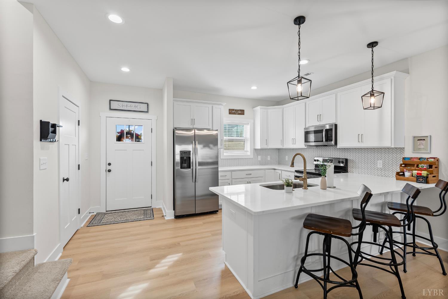 556 Leesville Road, Unit 1001 Lynchburg, VA 24502 - Photo 5 of 22 a kitchen with stainless steel appliances kitchen island a table chairs refrigerator and microwave