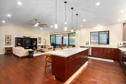 a large kitchen with kitchen island a stove a sink a center island and a couch