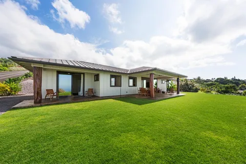 a view of a house with a yard and sitting area
